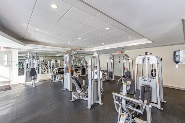 gym featuring a paneled ceiling and a tray ceiling