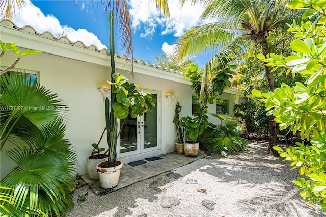 view of exterior entry featuring french doors and a patio