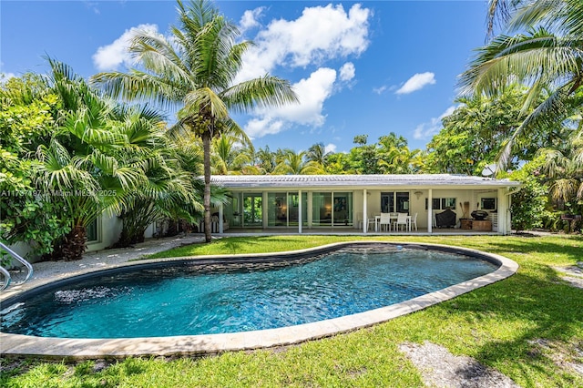 view of pool featuring a lawn