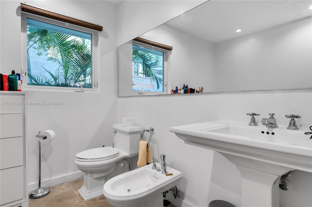 bathroom with a bidet, sink, tile patterned floors, and toilet