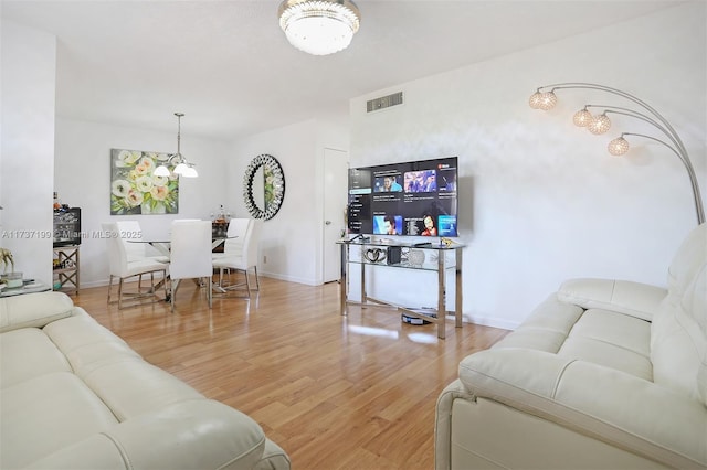 living room with wood-type flooring and an inviting chandelier