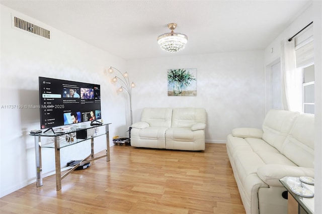 living room featuring an inviting chandelier and light hardwood / wood-style floors