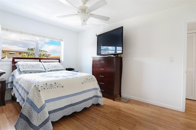 bedroom with ceiling fan, a textured ceiling, and light wood-type flooring