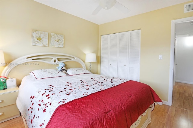 bedroom featuring ceiling fan, light hardwood / wood-style floors, and a closet