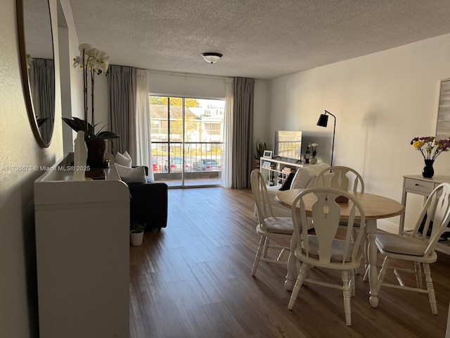 dining area with hardwood / wood-style flooring and a textured ceiling