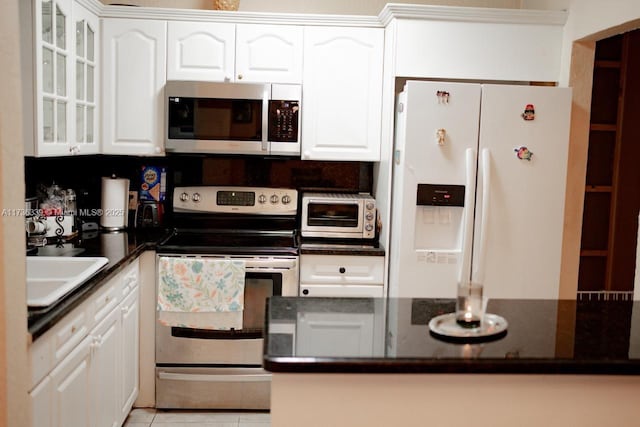 kitchen featuring stainless steel appliances, white cabinetry, sink, and light tile patterned flooring