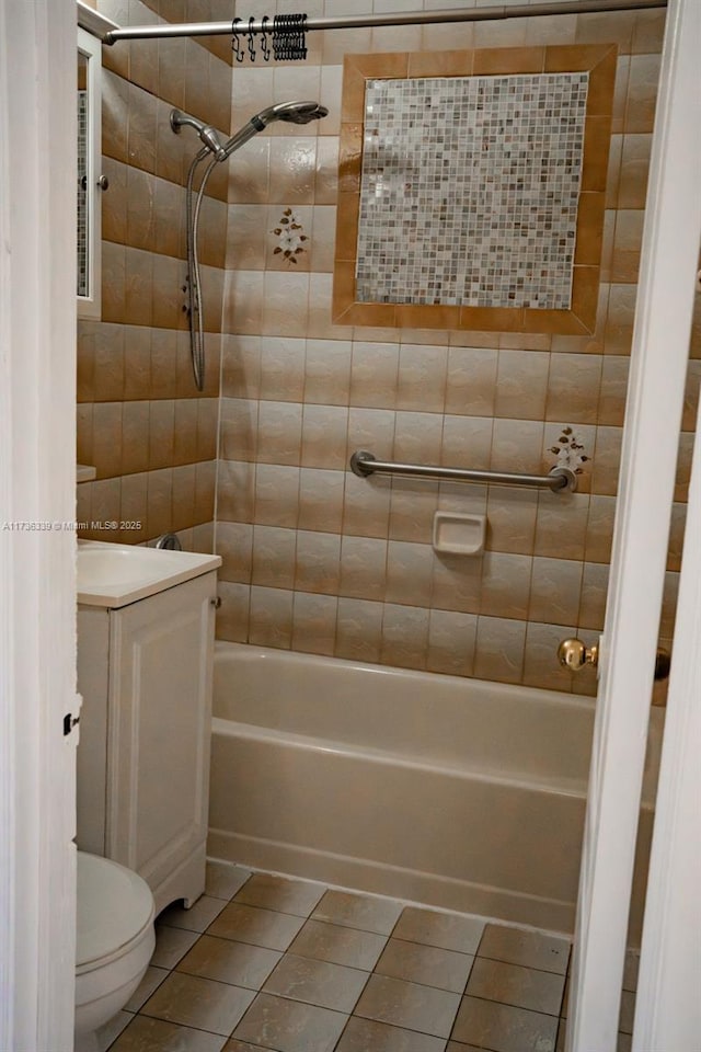 full bathroom featuring tiled shower / bath combo, vanity, tile patterned flooring, and toilet