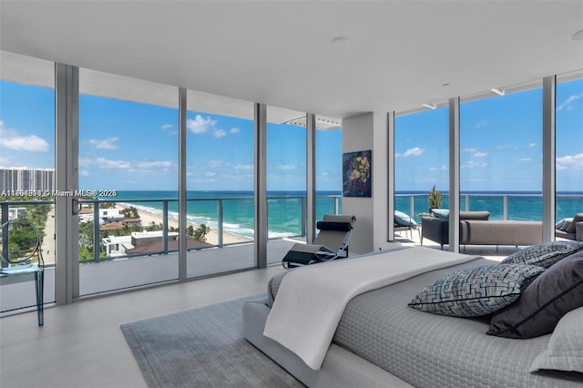 bedroom with a wall of windows, a beach view, and a water view