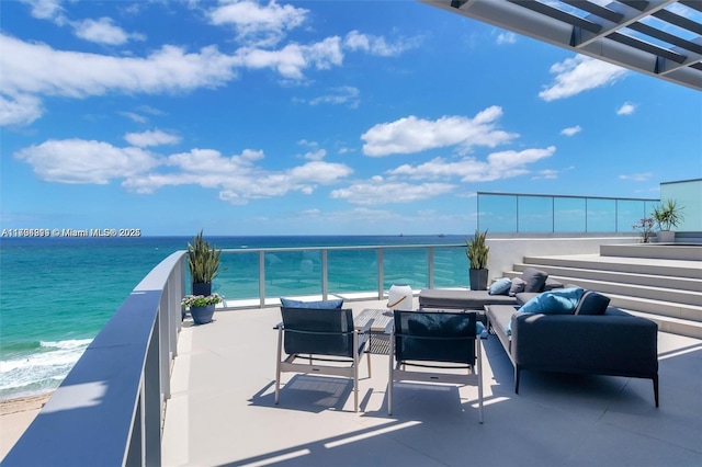 balcony featuring an outdoor living space, a beach view, and a water view