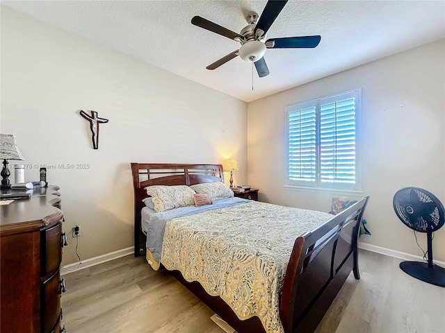 bedroom featuring ceiling fan, a textured ceiling, and light wood-type flooring