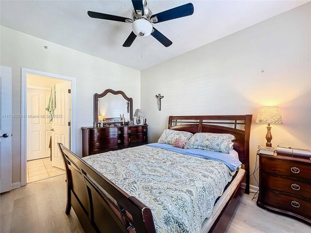 bedroom with ceiling fan, light hardwood / wood-style floors, and a textured ceiling