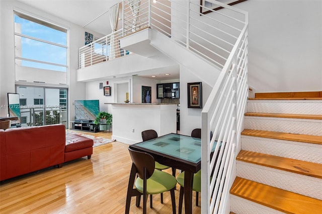 dining area featuring a high ceiling and hardwood / wood-style flooring