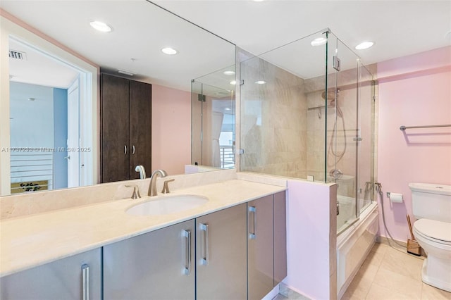 full bathroom featuring vanity, tile patterned floors, shower / bath combination with glass door, and toilet