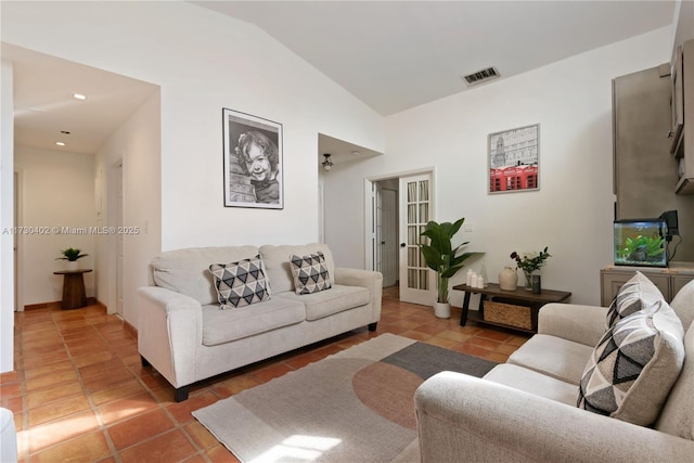 living room with lofted ceiling and dark tile patterned floors