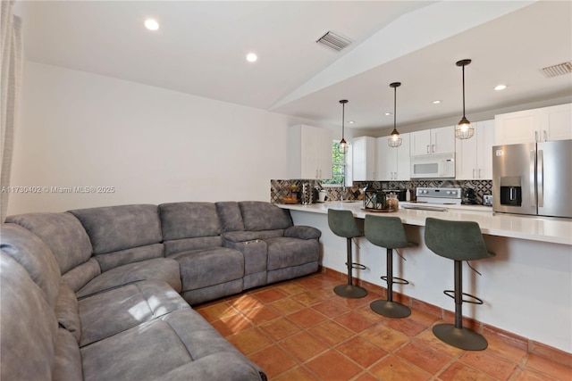 tiled living room featuring vaulted ceiling