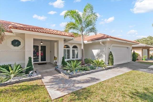 mediterranean / spanish-style home featuring a garage, a front lawn, and french doors