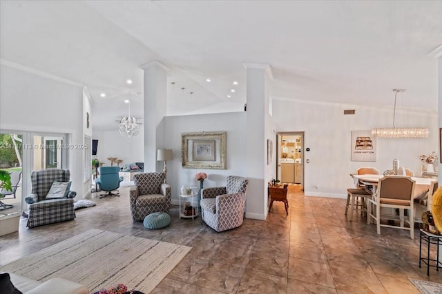 living room with a towering ceiling, washing machine and dryer, ornamental molding, a chandelier, and ornate columns