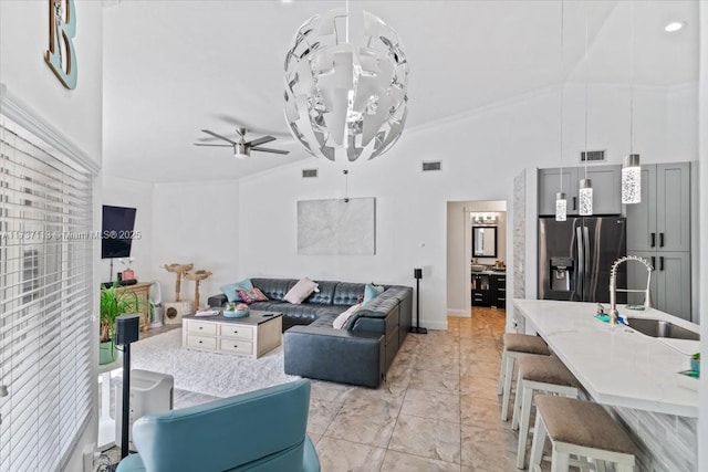 living room featuring crown molding, ceiling fan, high vaulted ceiling, and sink