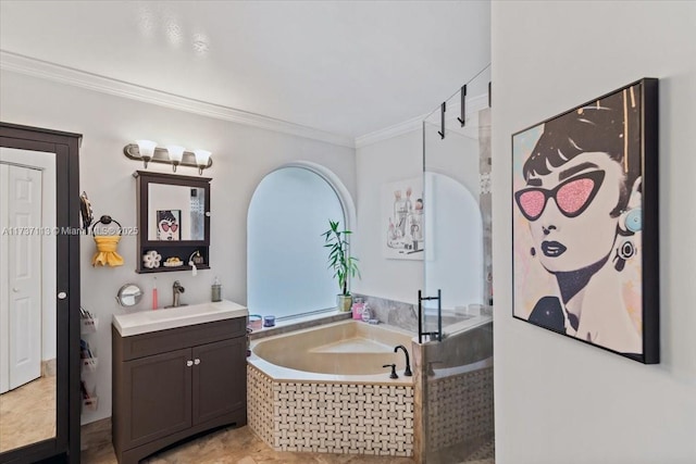 bathroom featuring tiled tub, vanity, and crown molding