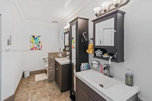 bathroom with vanity, crown molding, and toilet