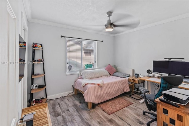 bedroom with hardwood / wood-style floors, ornamental molding, and ceiling fan