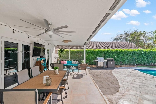 view of patio with french doors, ceiling fan, a grill, and a fenced in pool