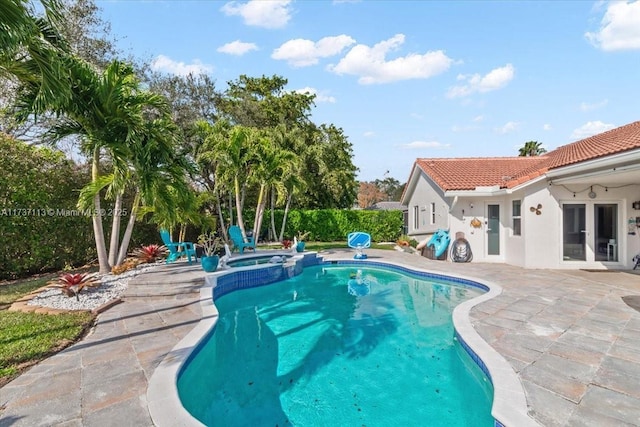 view of swimming pool featuring a patio area and an in ground hot tub