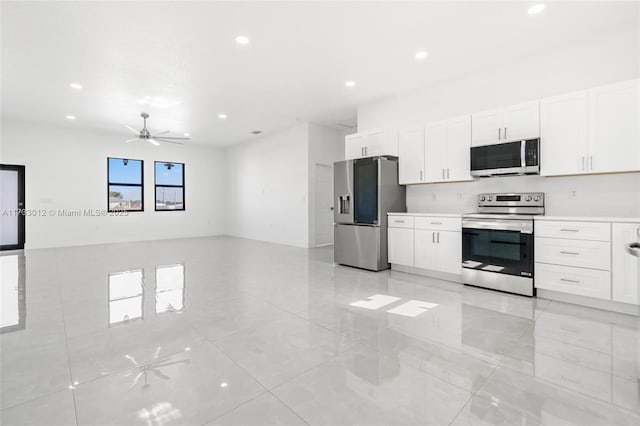 kitchen featuring stainless steel appliances, light countertops, and white cabinets