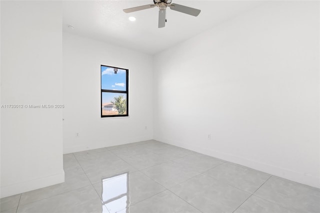 spare room featuring baseboards, a ceiling fan, and light tile patterned flooring