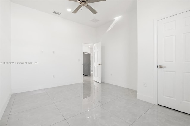 spare room with baseboards, visible vents, ceiling fan, and light tile patterned flooring