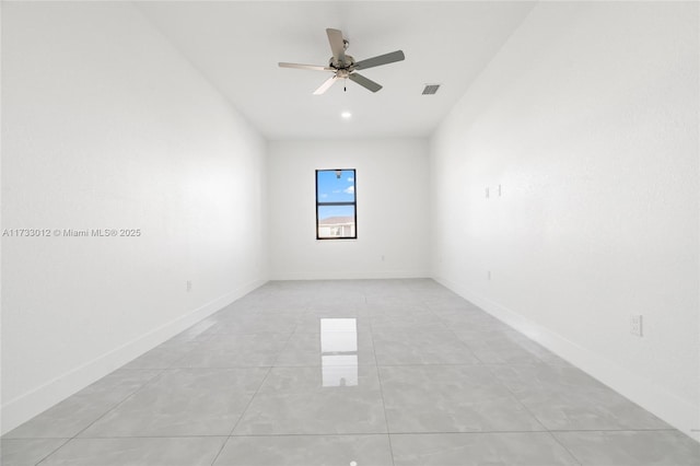 empty room with light tile patterned floors, baseboards, visible vents, and ceiling fan