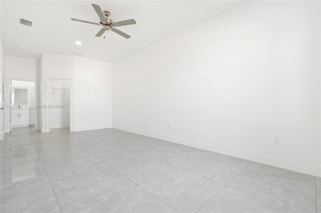 empty room with ceiling fan, visible vents, and baseboards