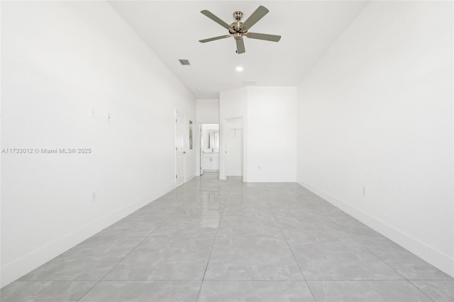 empty room with baseboards, visible vents, and ceiling fan