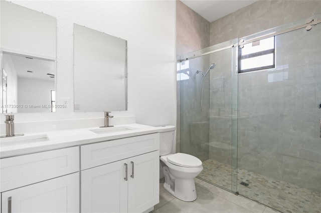 bathroom with toilet, a stall shower, double vanity, and a sink