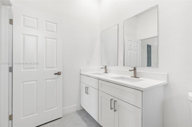 bathroom featuring double vanity, a sink, and toilet