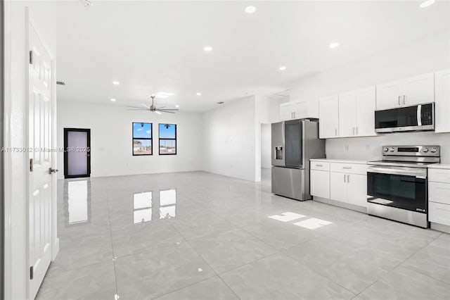 kitchen featuring stainless steel appliances, light countertops, white cabinetry, and recessed lighting