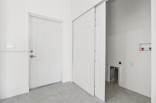 interior space with washer hookup, light tile patterned floors, electric dryer hookup, laundry area, and baseboards