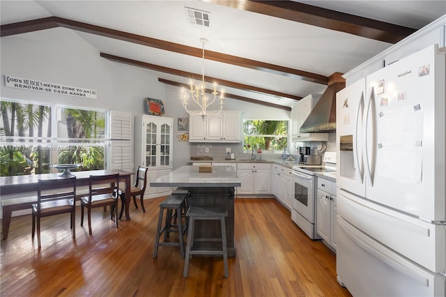 kitchen featuring sink, white appliances, white cabinetry, a kitchen island, and wall chimney exhaust hood