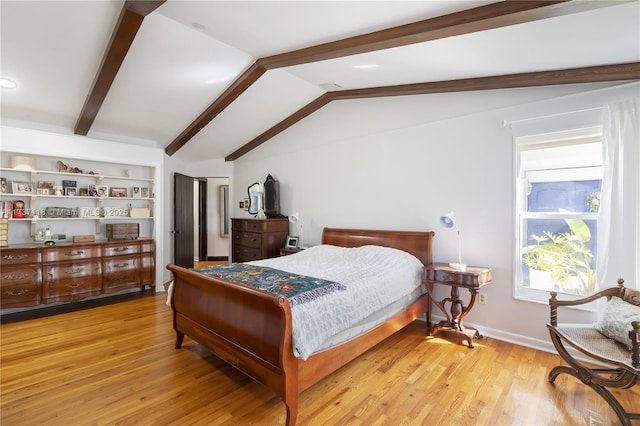 bedroom with lofted ceiling with beams and light hardwood / wood-style floors