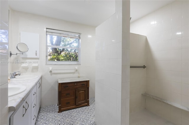 bathroom with tile patterned flooring, vanity, and tile walls