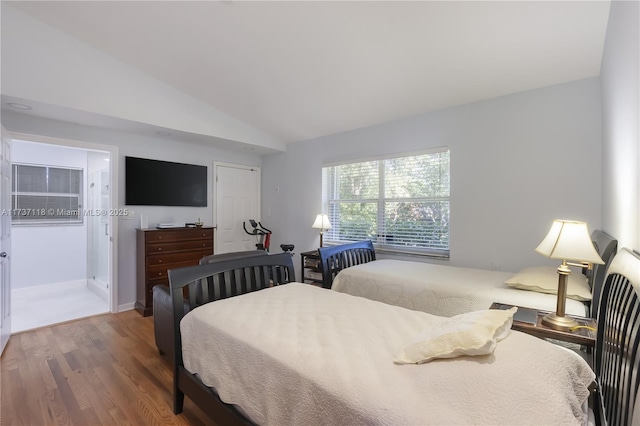 bedroom with wood-type flooring, vaulted ceiling, and a closet