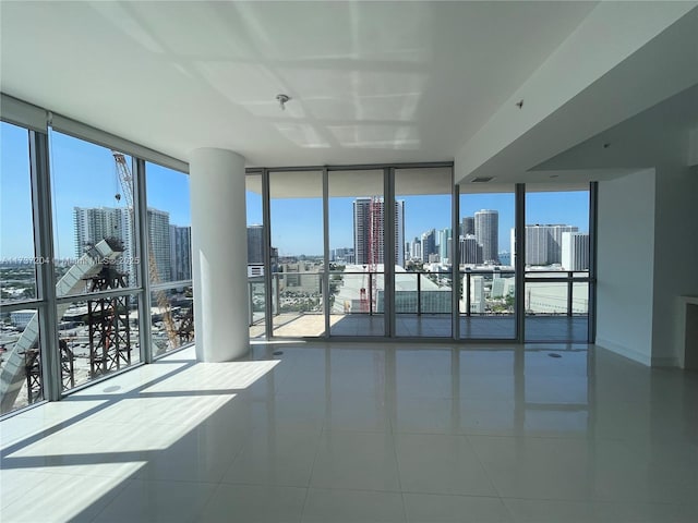 tiled empty room featuring floor to ceiling windows