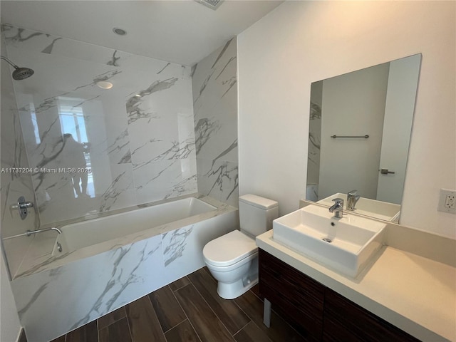 full bathroom with vanity, tiled shower / bath combo, and toilet