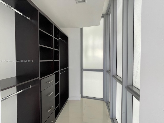 walk in closet with light tile patterned floors