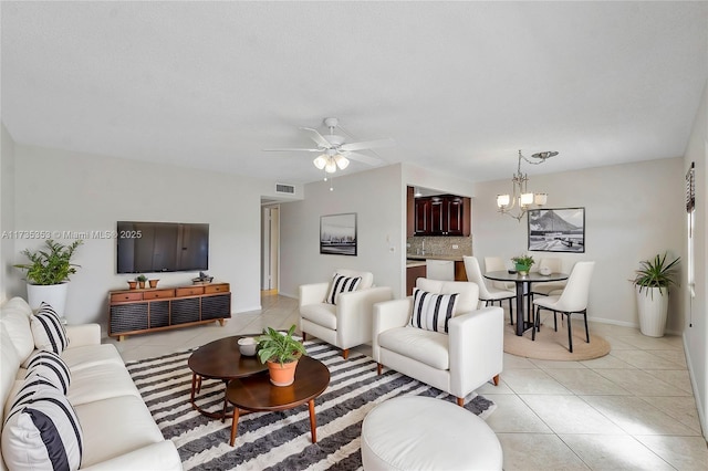 tiled living room featuring ceiling fan with notable chandelier