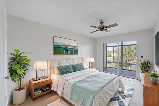 bedroom featuring ceiling fan, light colored carpet, a textured ceiling, and access to outside