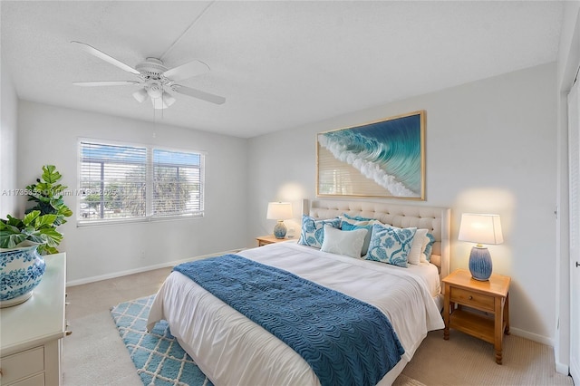 bedroom featuring light carpet, a textured ceiling, and ceiling fan