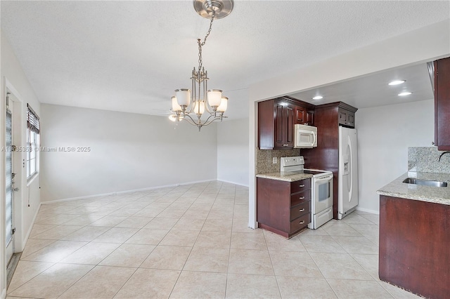 kitchen with sink, pendant lighting, white appliances, light stone countertops, and decorative backsplash