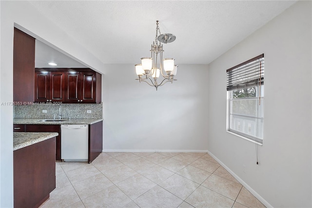 kitchen featuring decorative light fixtures, tasteful backsplash, dishwasher, sink, and a notable chandelier