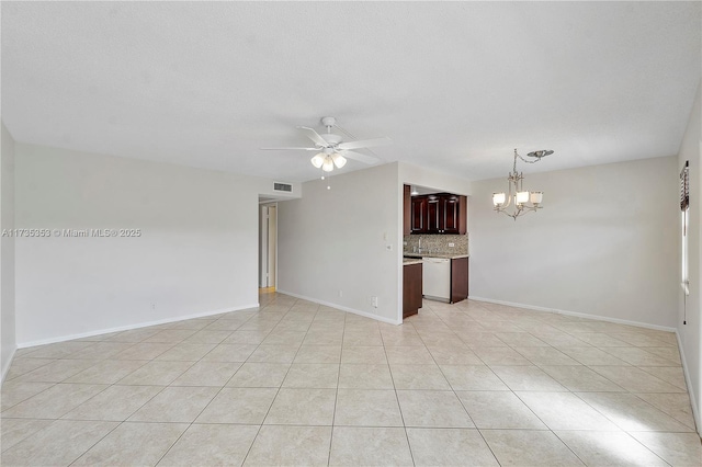 empty room with ceiling fan with notable chandelier, a textured ceiling, and light tile patterned floors